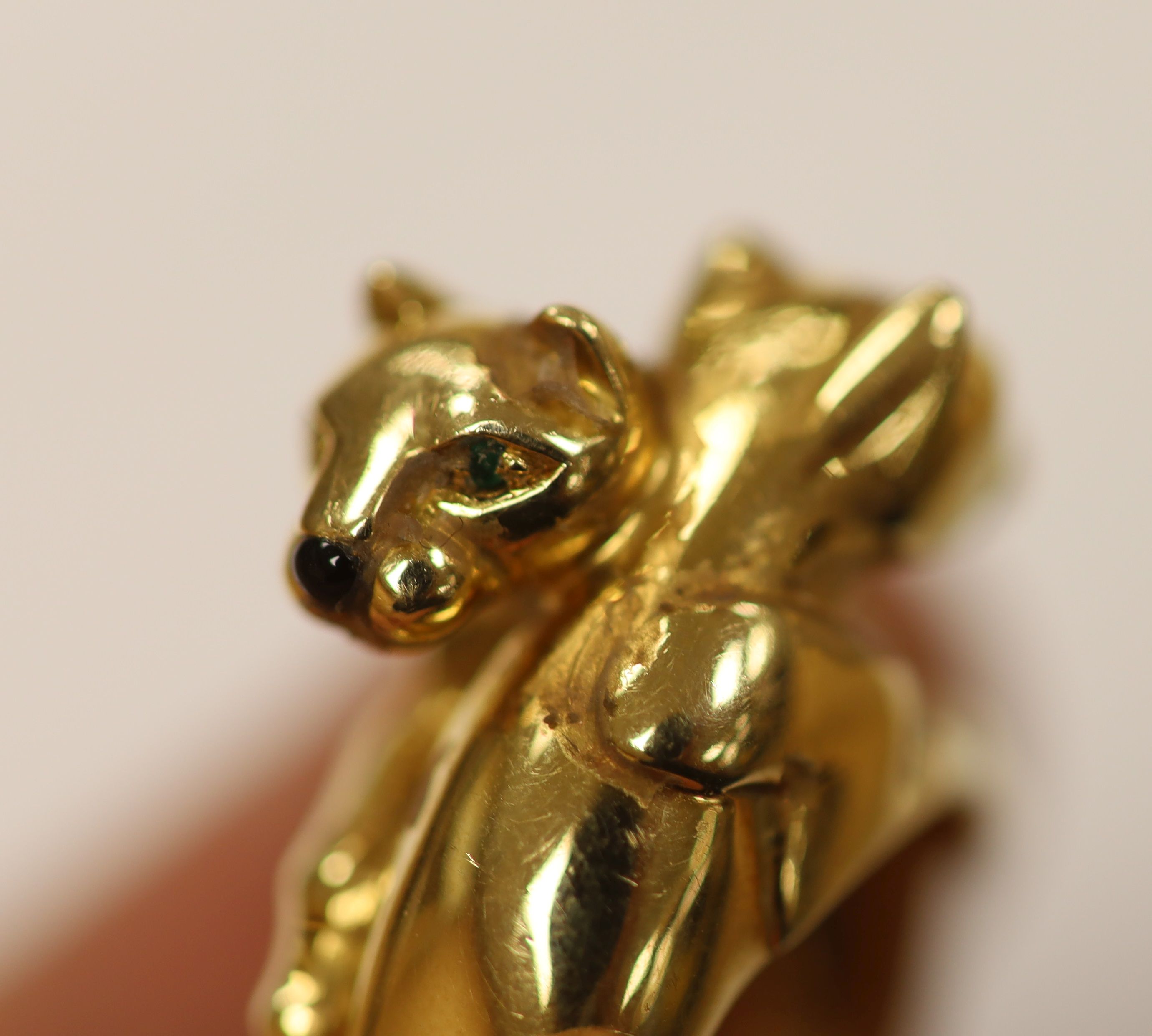 An early 1990's Cartier 18ct gold, black onyx and emerald set twin leopard's head crossover ring